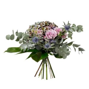 Bukett med blommor i lila; hortensia, rosor, tistel och gröna blad. Blommorna finns att beställa online hos Interflora.