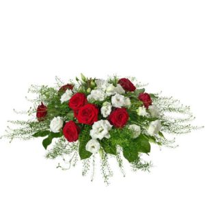 Rundbunden begravningsdekoration med rosor, eustoma och tallapsi. Blommor i rött och vitt. Dekorationen ingår i Interfloras utbud av begravningsblommor.
