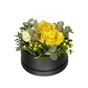 En rund box (18 cm i diameter), fylld med gula rosor, johannesört, nejlikor, blandat grönt och torkat. Superfin! Skicka den med ett blommogram från Interflora - beställ enkelt online.