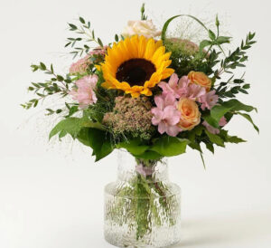 Bukett med gul solros, kärleksört, rosor, alstroemeria och dekorationsgrönt. Skicka med blommogram från Interflora!